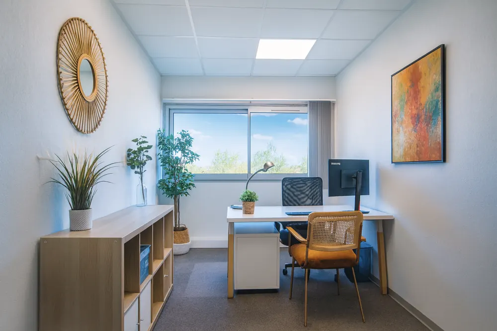 Bureau individuel au Millénaire avec deux écrans, fauteuil et rangements, pour une conférence à distance en solo
