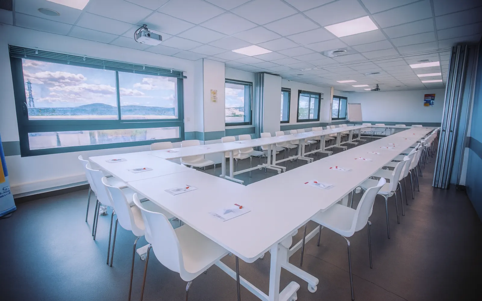 Grande salle Solea ouverte à Garosud, tables en U face à l'écran de projection, jusqu'à cent personnes