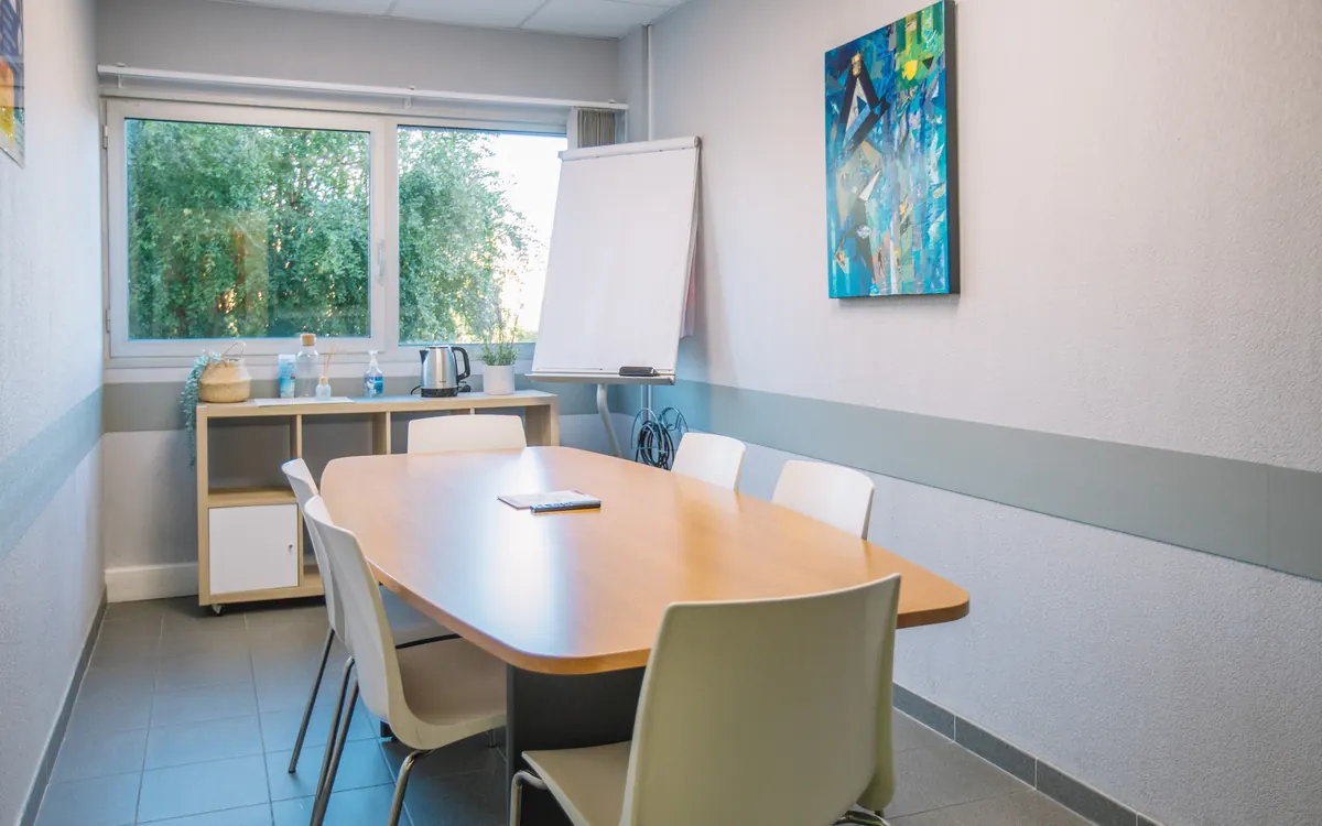 Salle de réunion de six personnes au Millénaire avec écran mural et paperboard